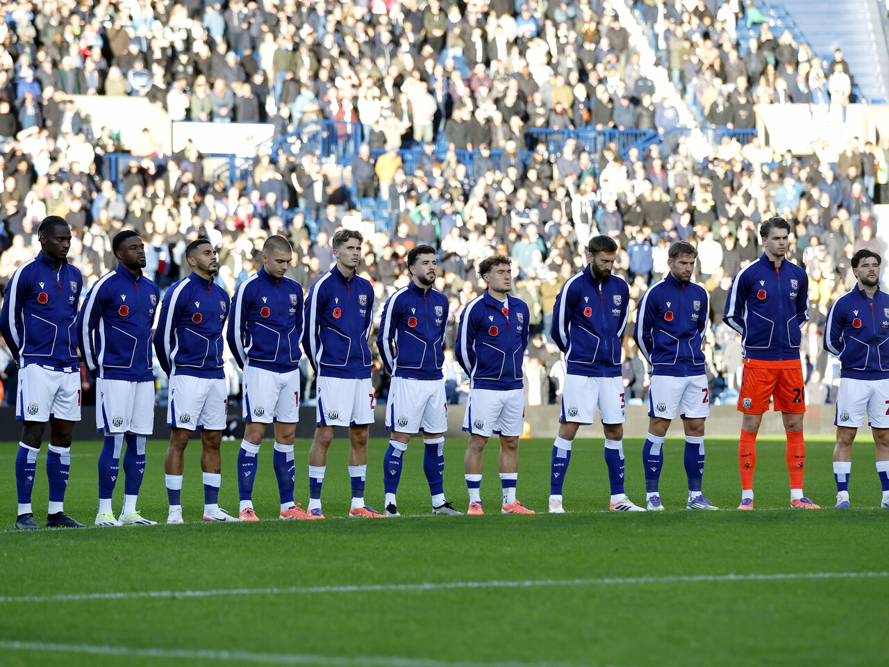 Albion's starting XI observe a period of silence before the game against Oxford on the pitch 