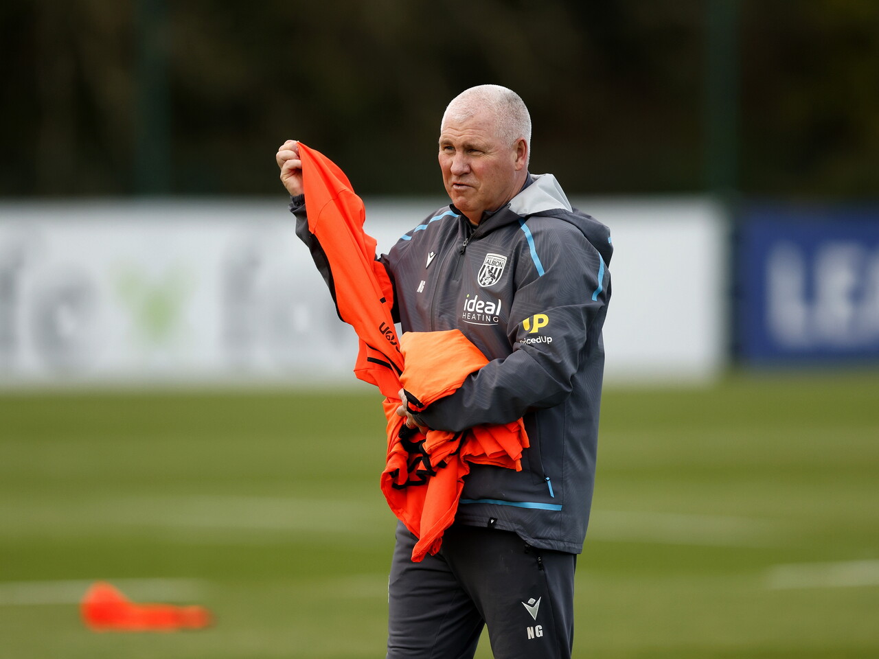 Nigel Gibbs handing out bibs during a training session