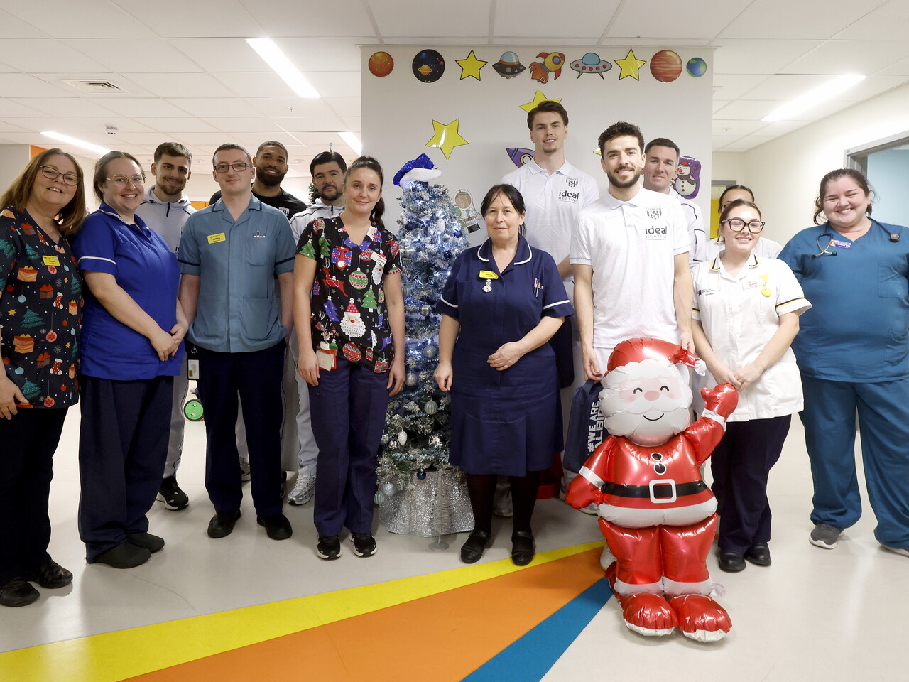 WBA players posing for a photo with NHS staff members on a ward at the Midlands Met hospital