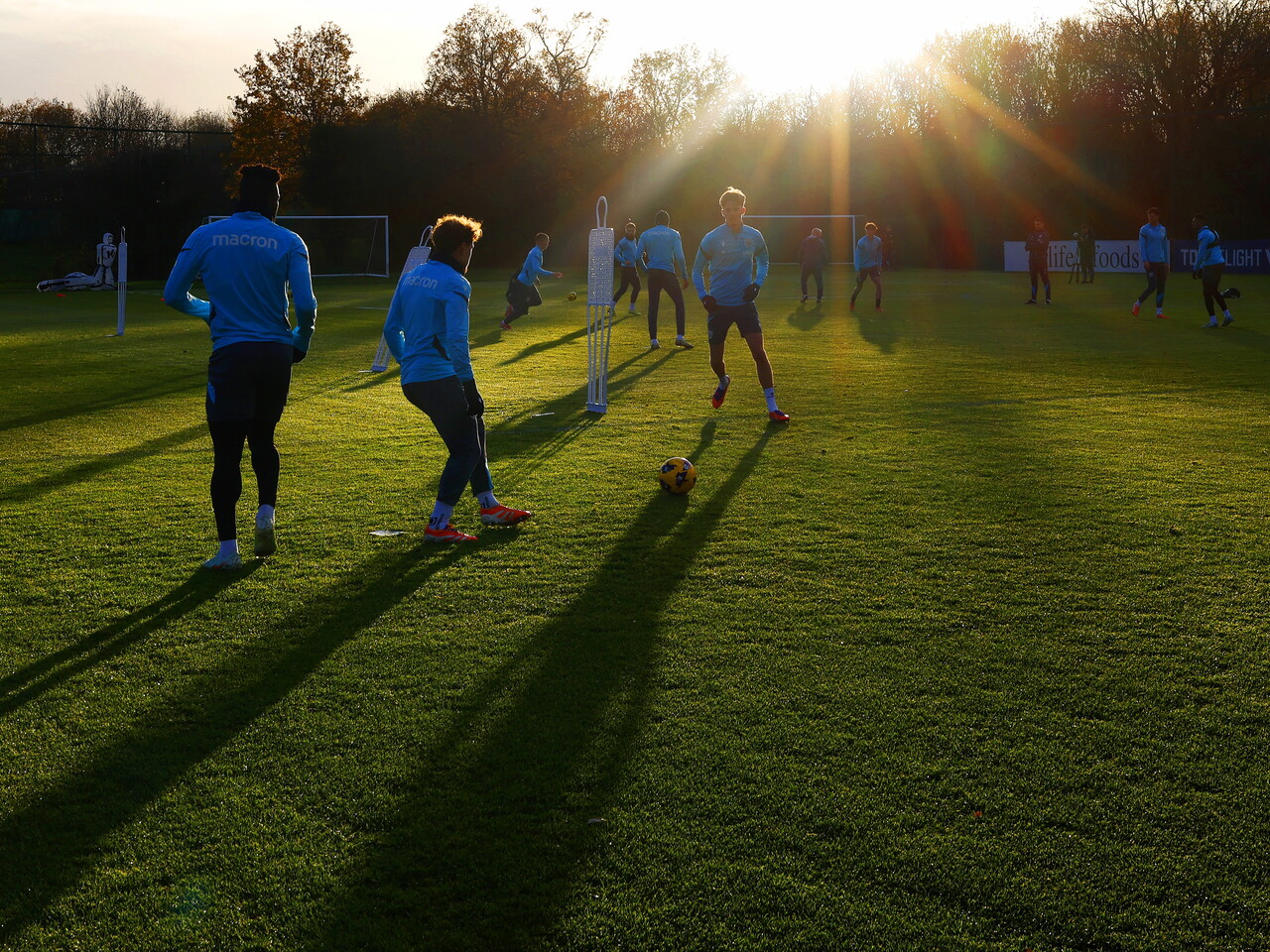 A general view of training with the sun in background and several players in shot