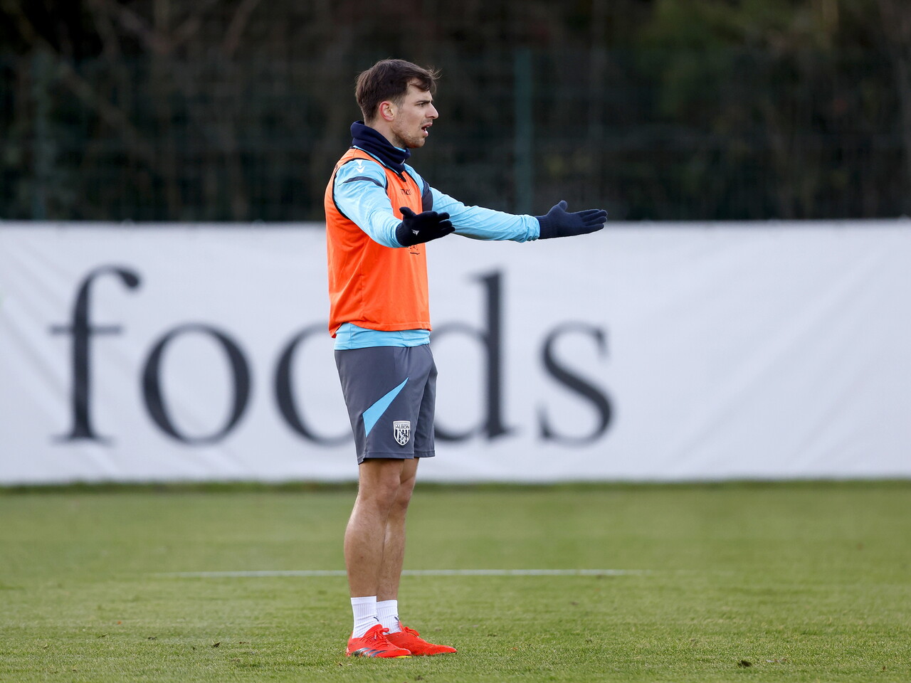Jayson Molumby with his arms outstretched during a training session