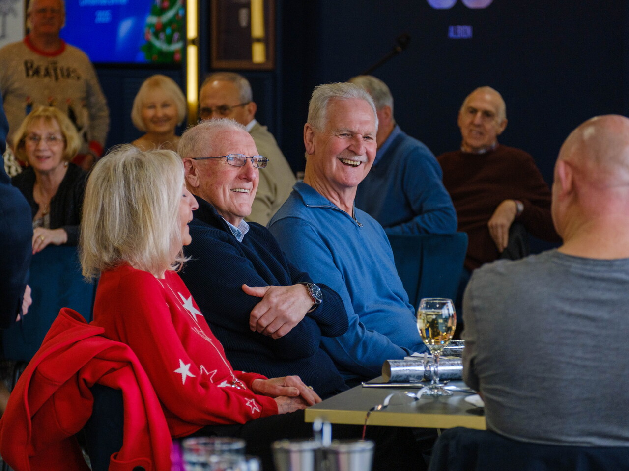 Tony “Bomber” Brown, his wife and Ally Robertson smiling at their table.