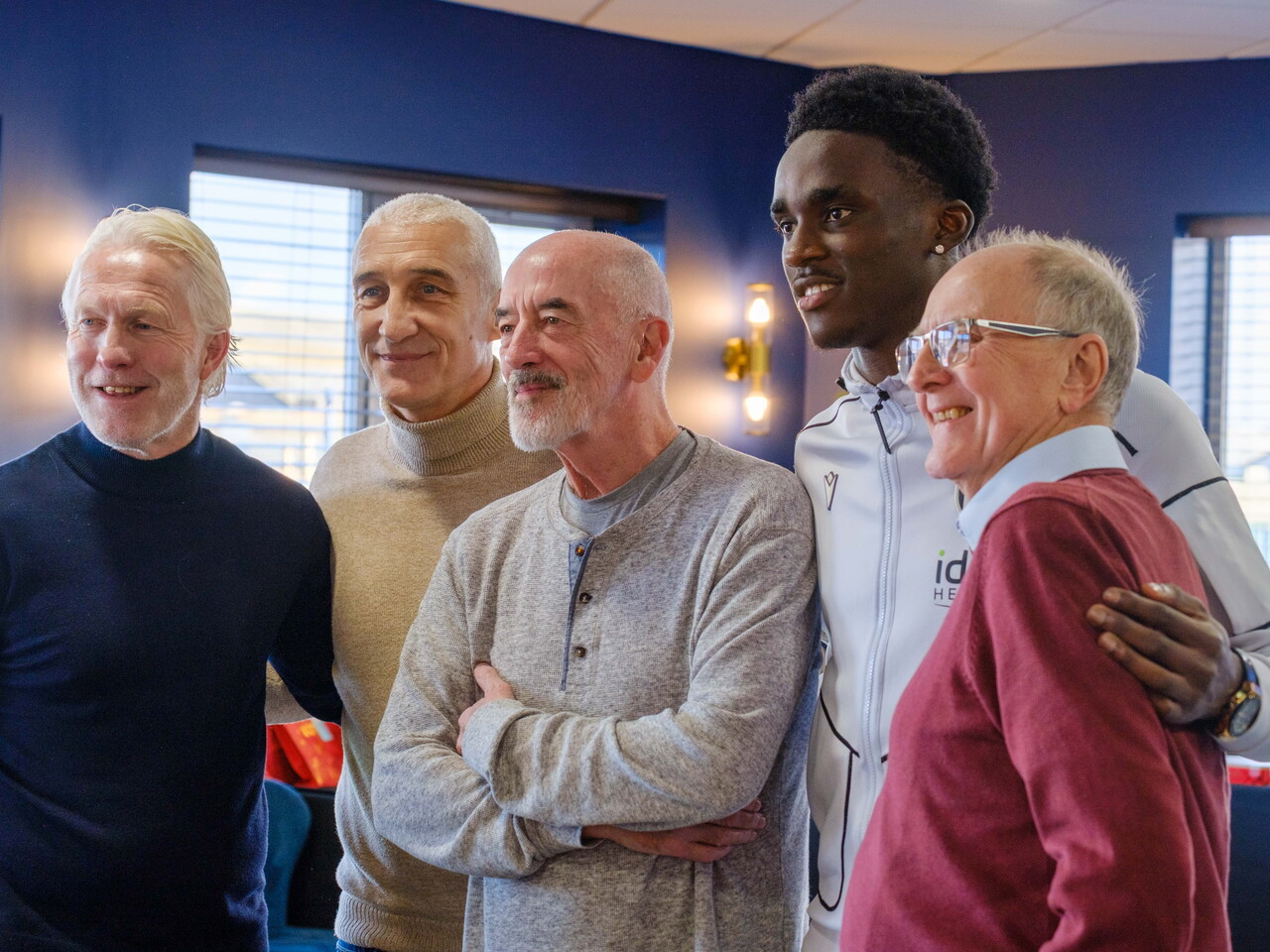 A scholar taking a photo with former players and participants.