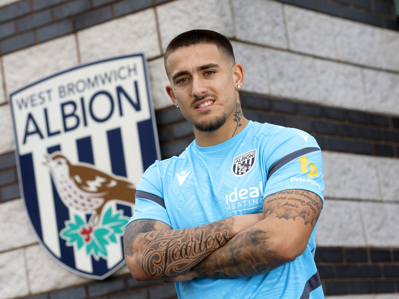 Danny Imray smiling at the camera with his arms crossed while stood outside the training ground