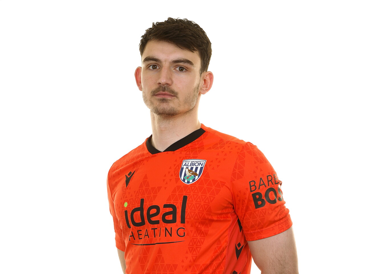 Max O'Leary looking at the camera while wearing an orange GK shirt