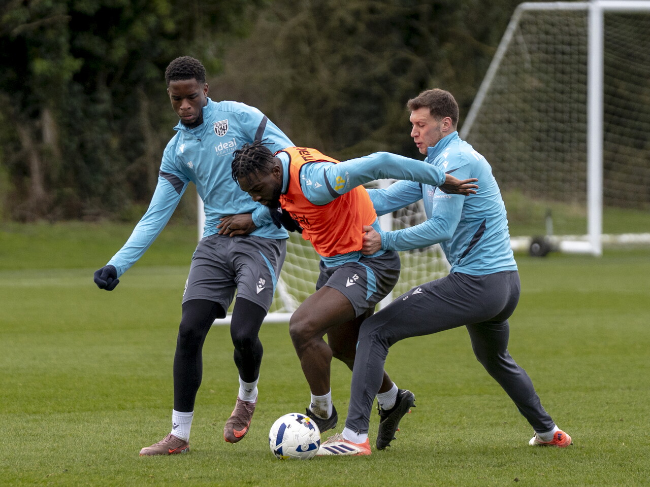 Daryl Dike on the ball during a training session holding off two players