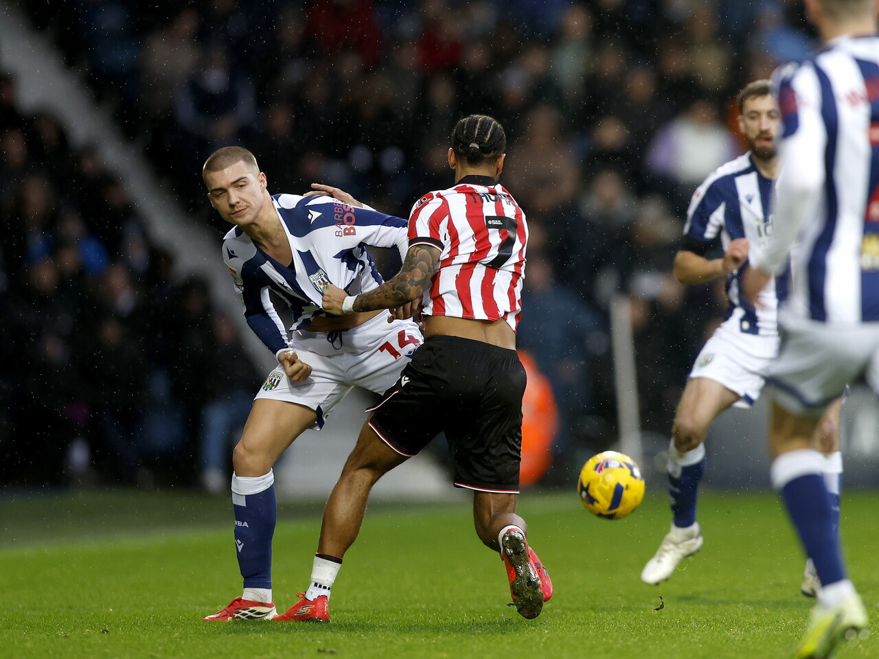 Alfie Gilchrist has his shirt pulled by a Stoke player