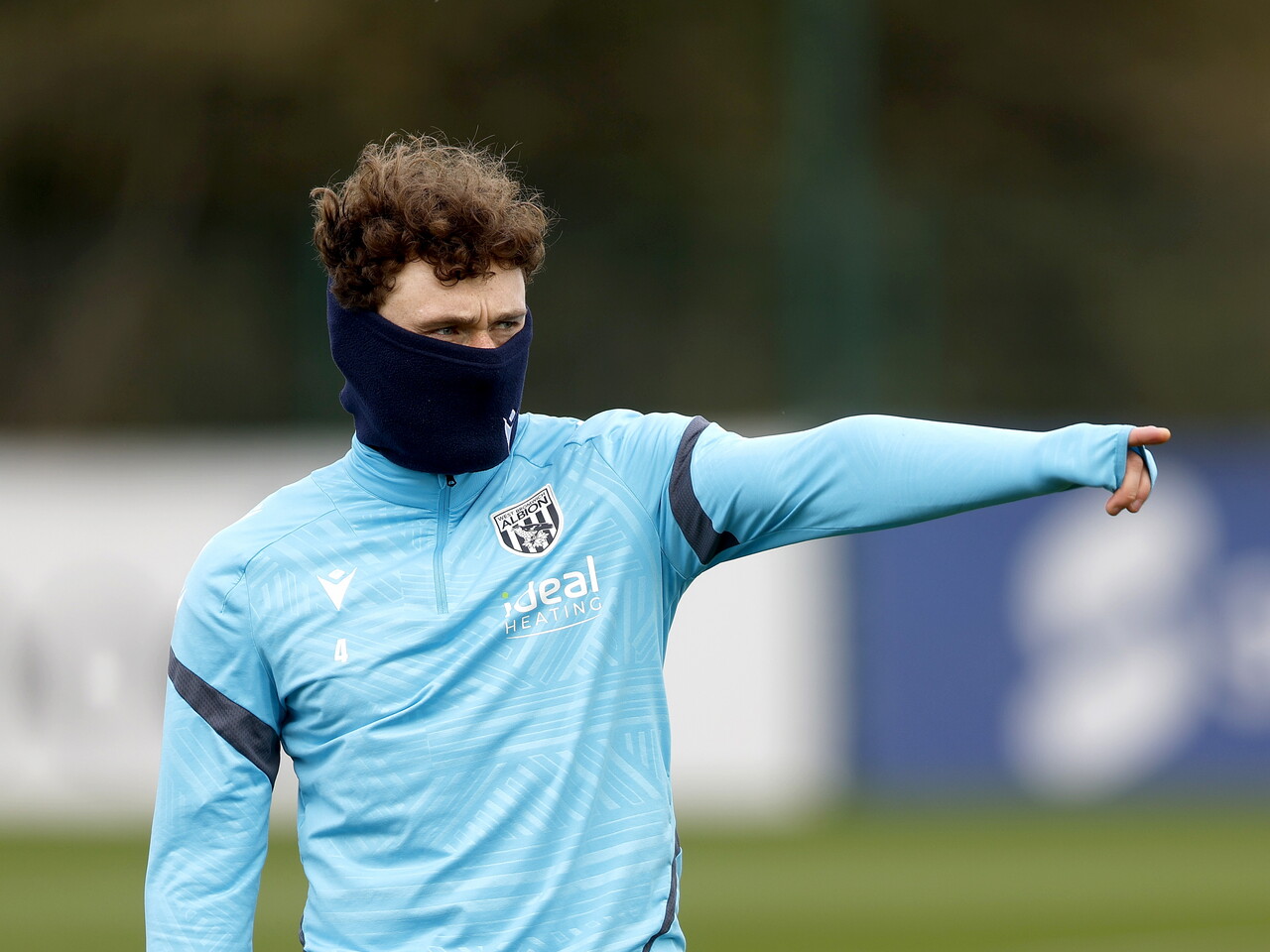 Callum Styles pointing while wearing a snood during training