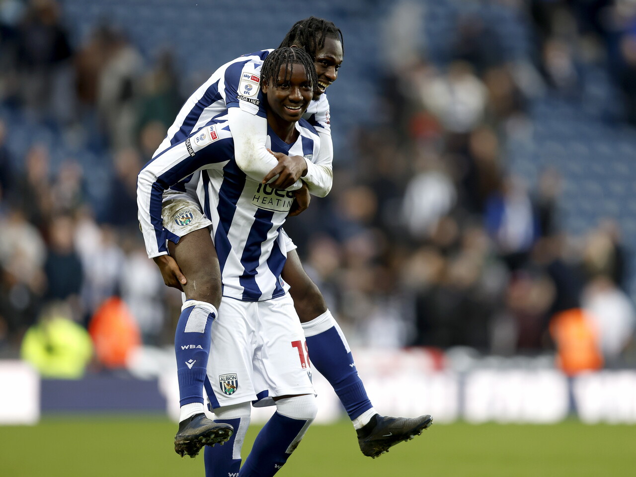 Ousmane Dikaité jumping on Jamal Jimoh-Aloba's back smiling