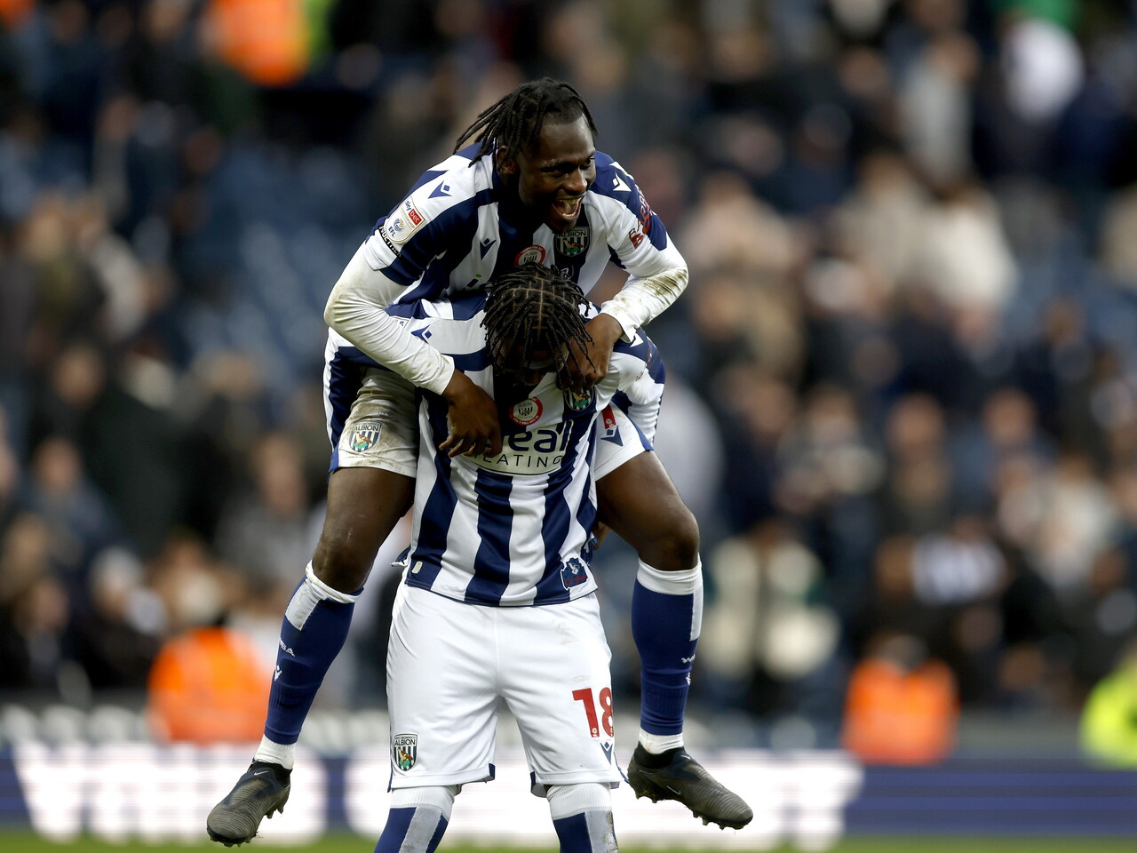 Ousmane Dikaité jumping on Jamal Jimoh-Aloba's back smiling