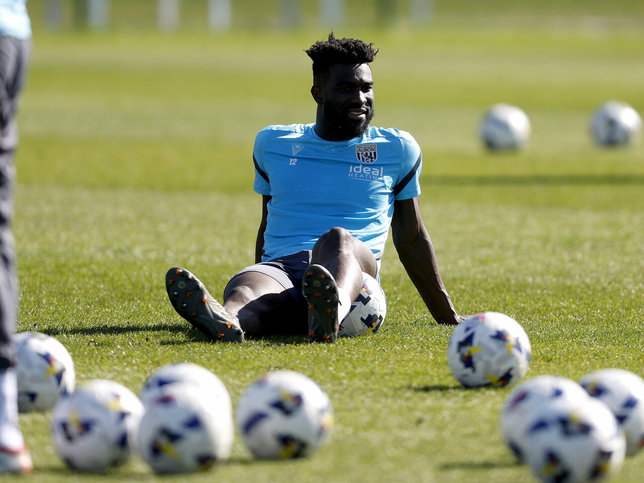Daryl Dike sat down on the training pitch surrounded by footballs