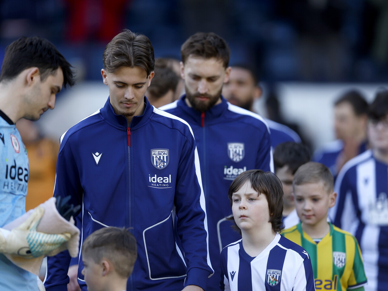 Isaac Price walking out of the tunnel with mascots