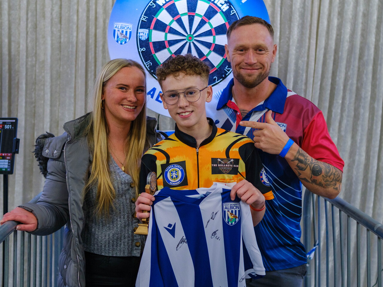 Codey with his parents holding the winner's trophy & signed WBA shirt.
