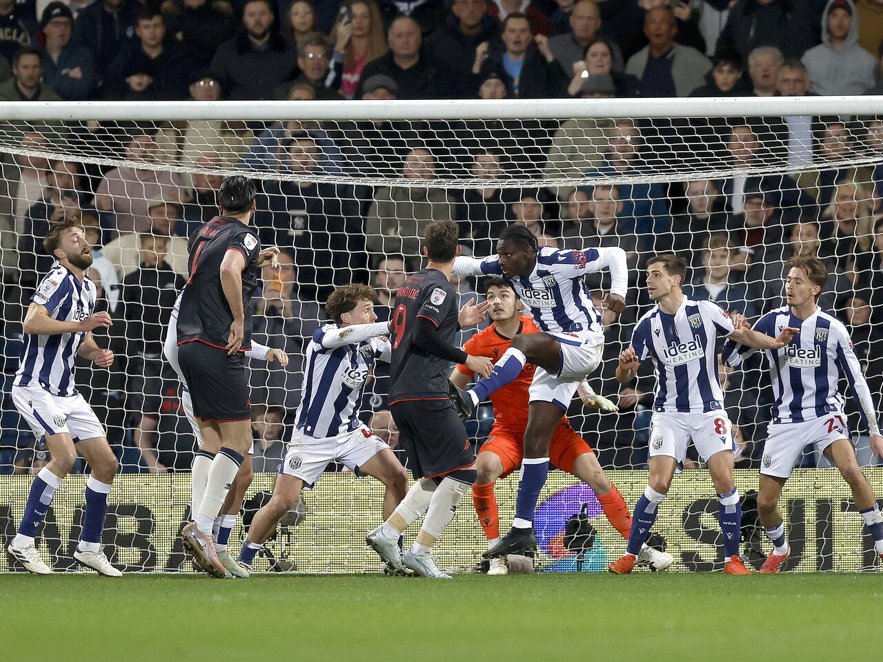 Several players looking for the ball in the penalty area 