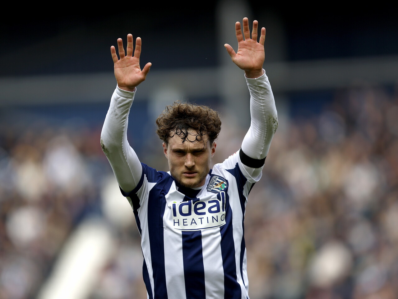 Callum Styles with his two arms up in the air during the game against Wrexham