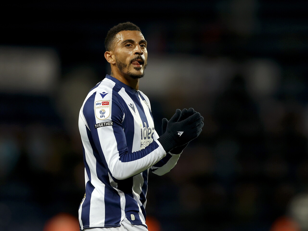 Karlan Grant applauds the fans at full-time