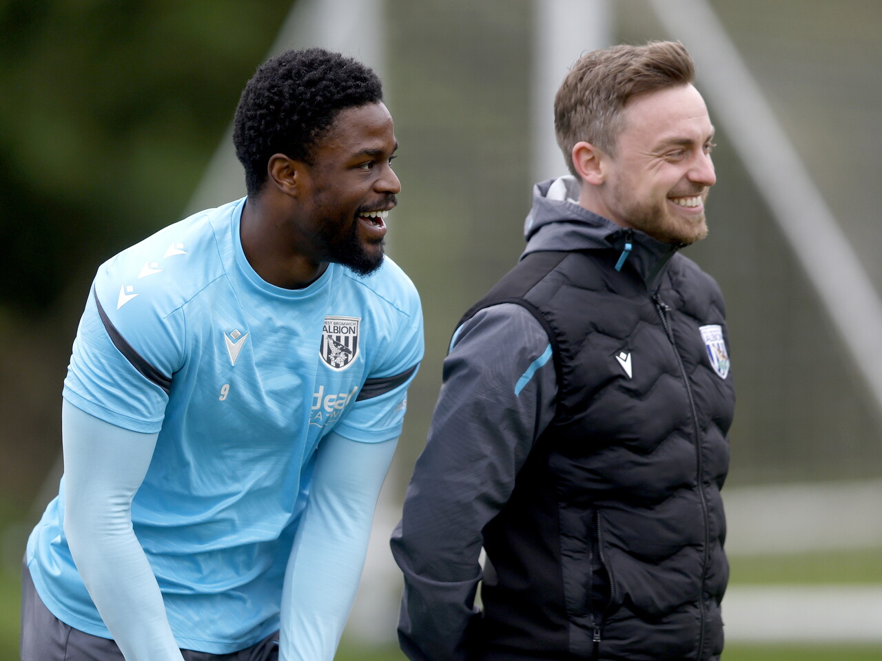 Josh Maja laughing with a member of staff during a training session