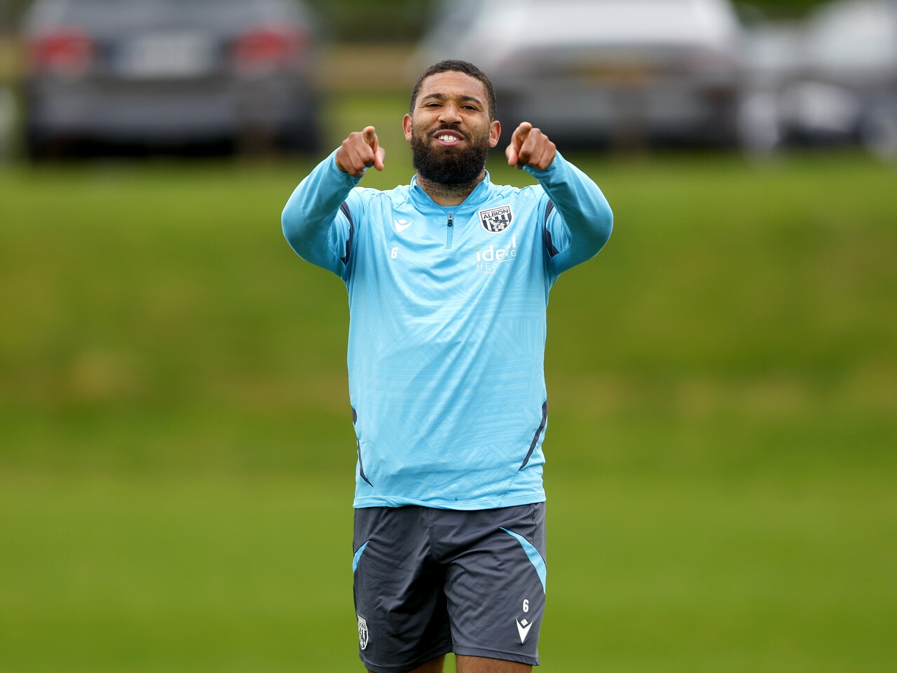 George Campbell smiling and pointing at the camera during a training session