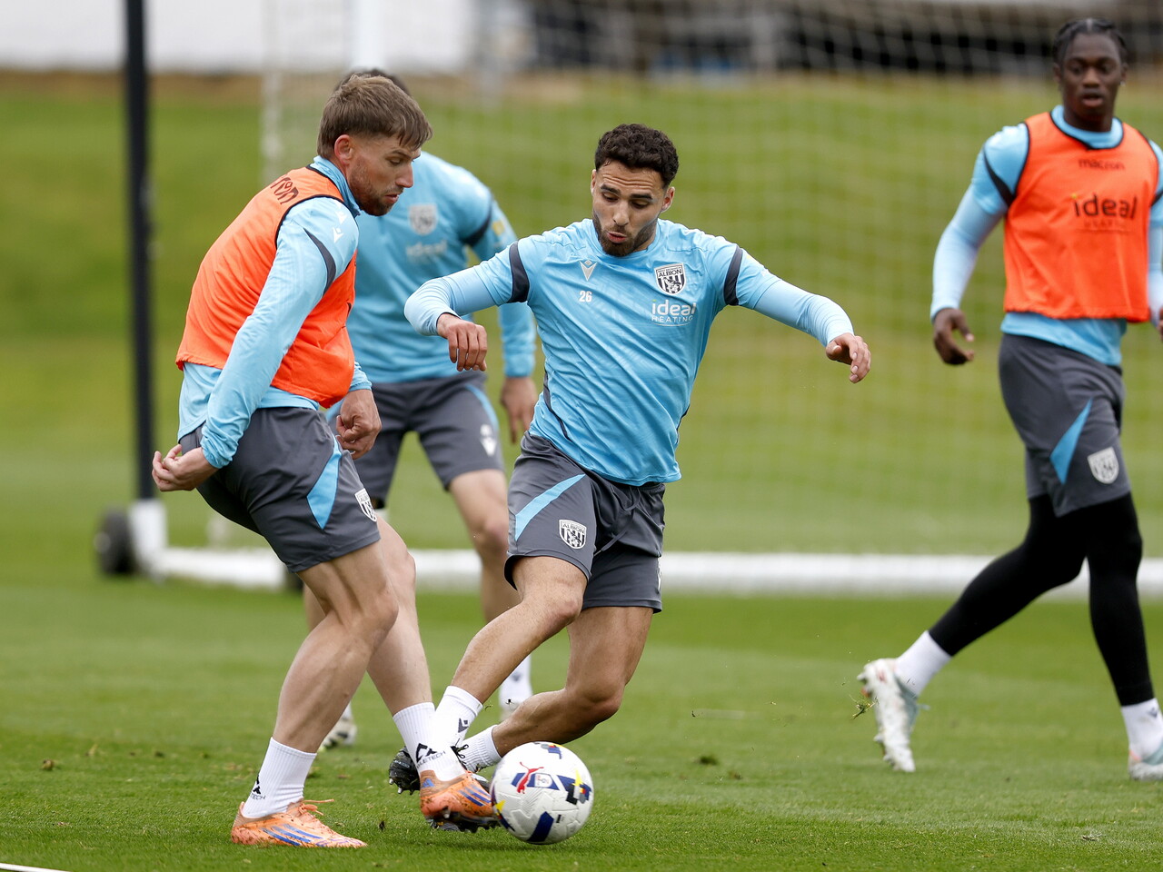 Charlie Taylor passing the ball during training, with Tammer Bany closing him down