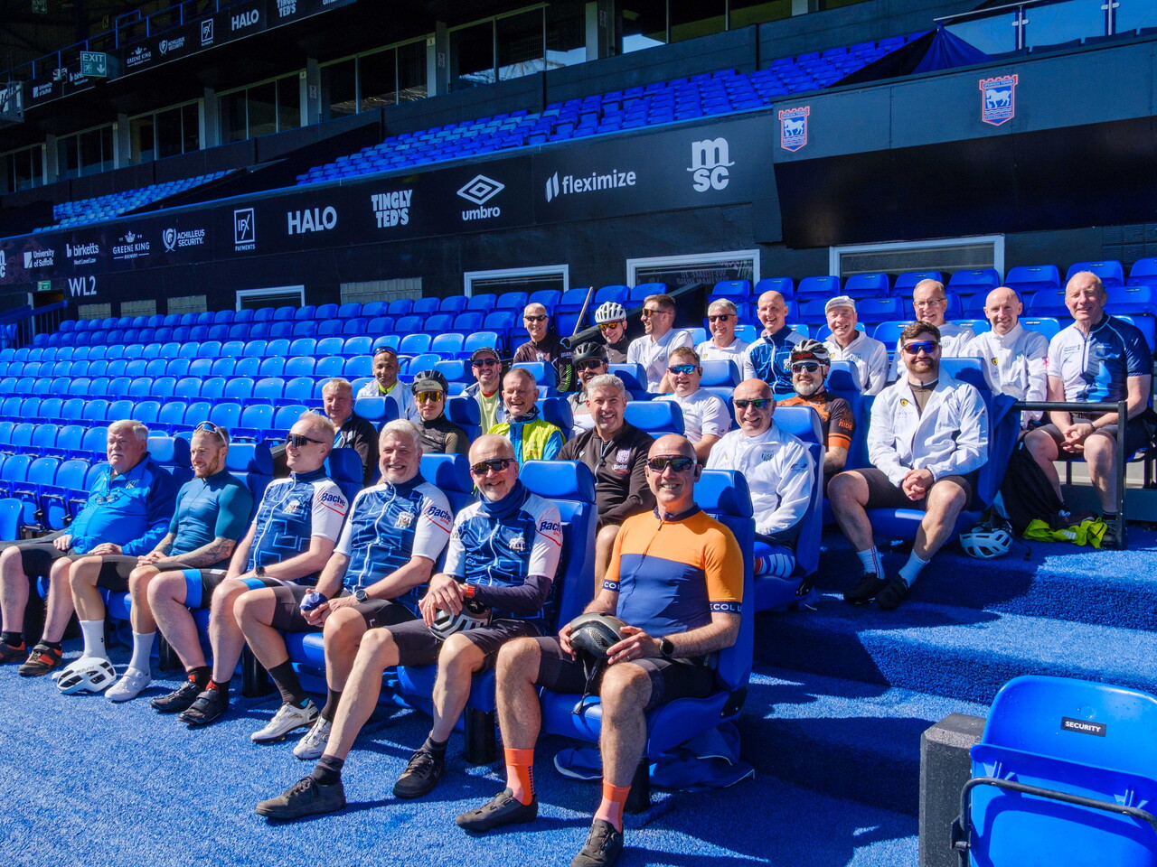 Cyclists seating in the Ipswich dugout
