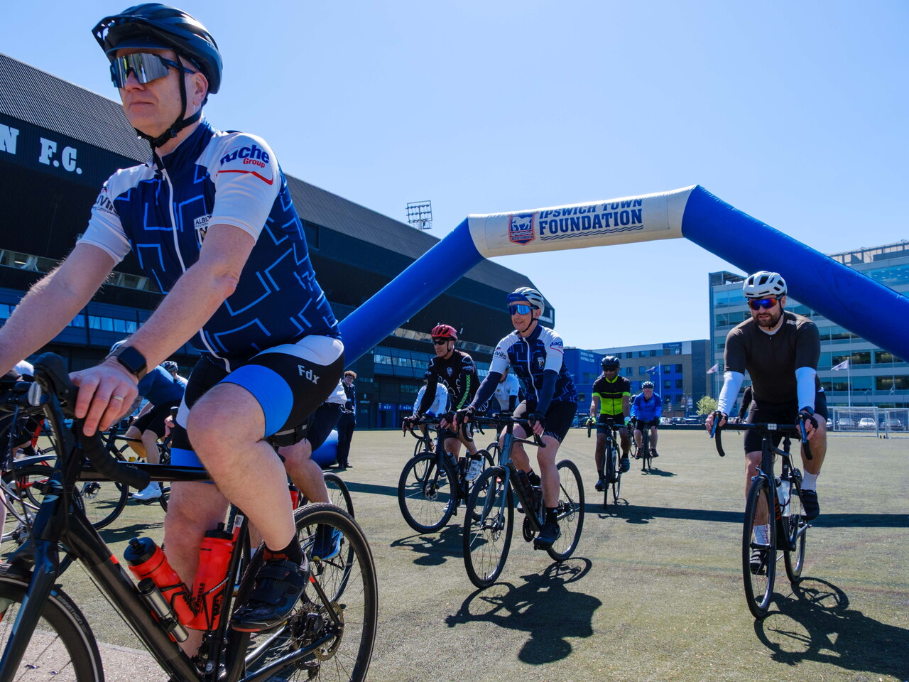 Cyclists riding through the inflatable arch.