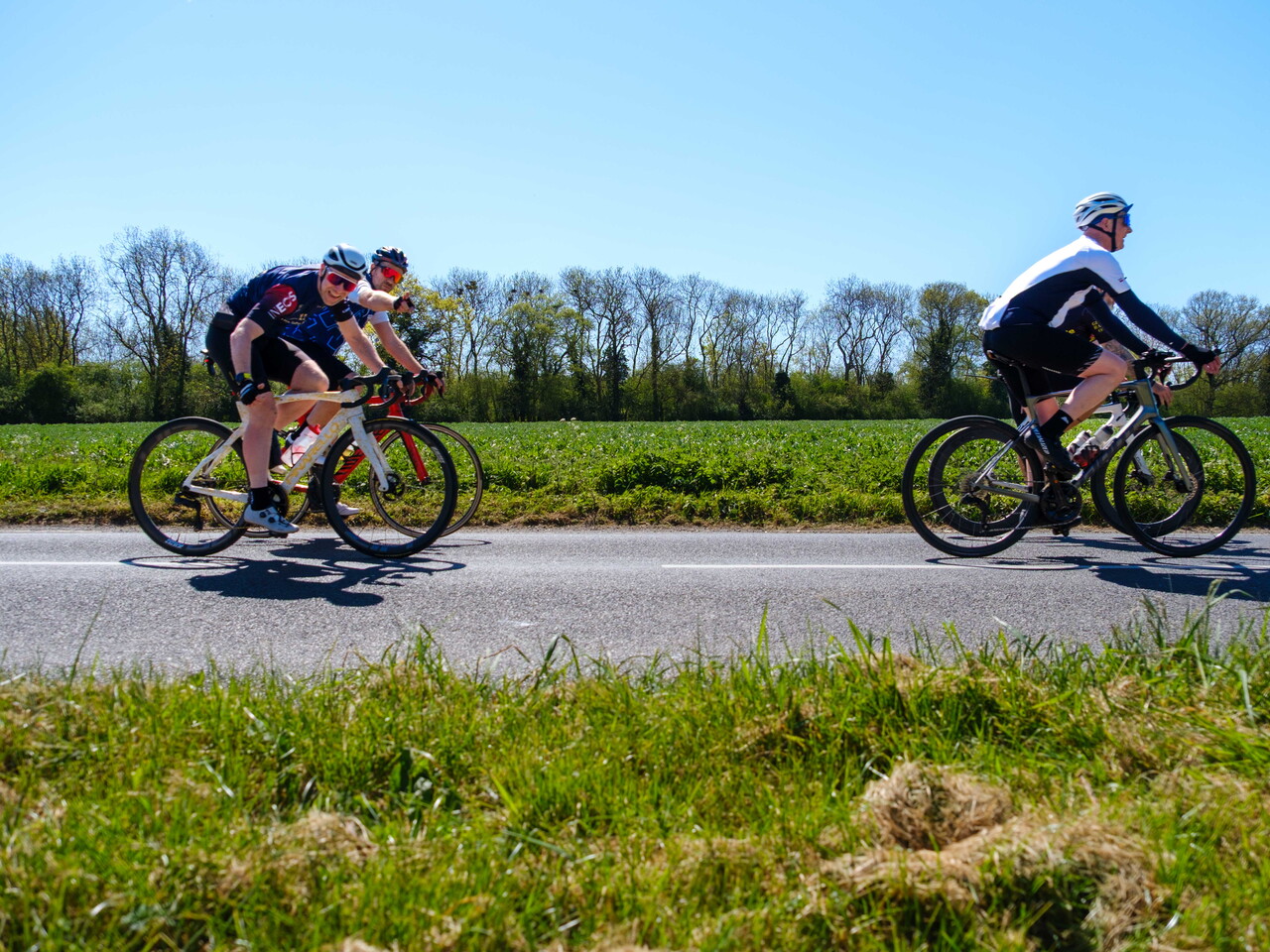 Cyclists riding down a country road.