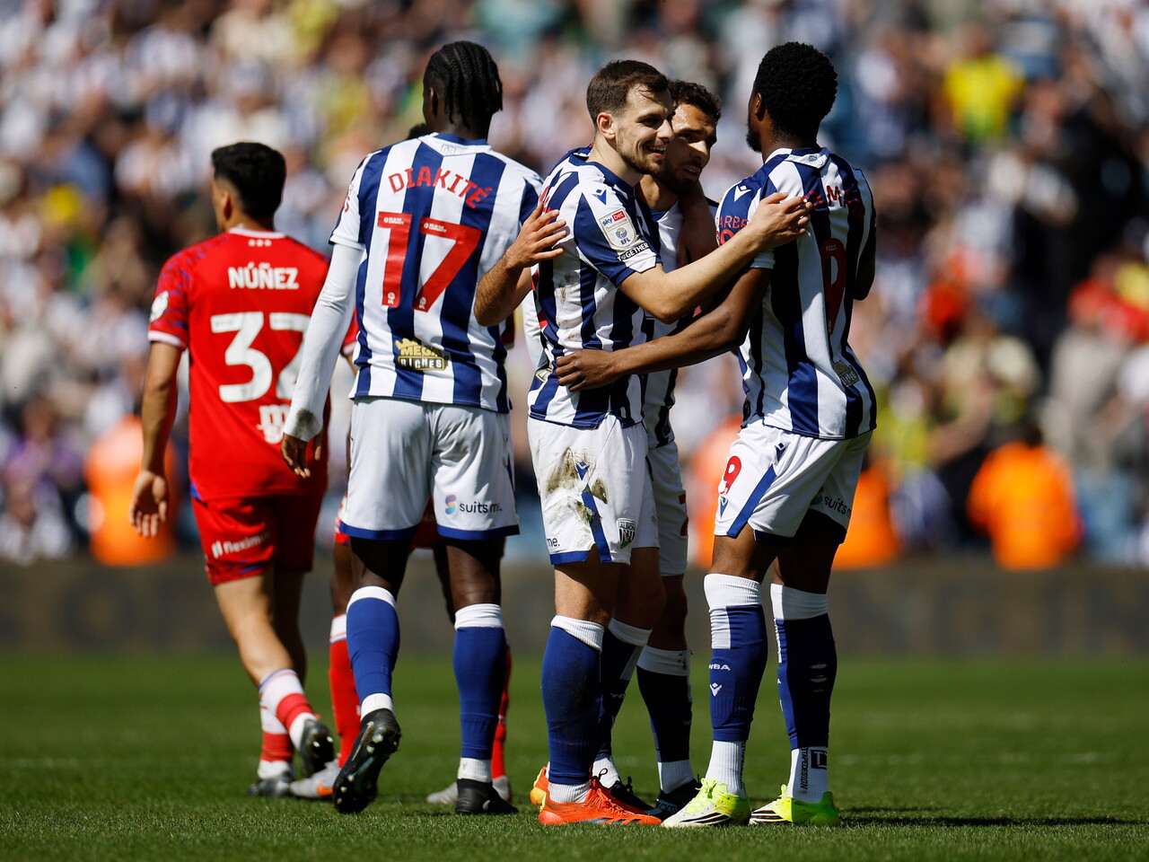 Several WBA players embrace and celebrate the point at full-time 