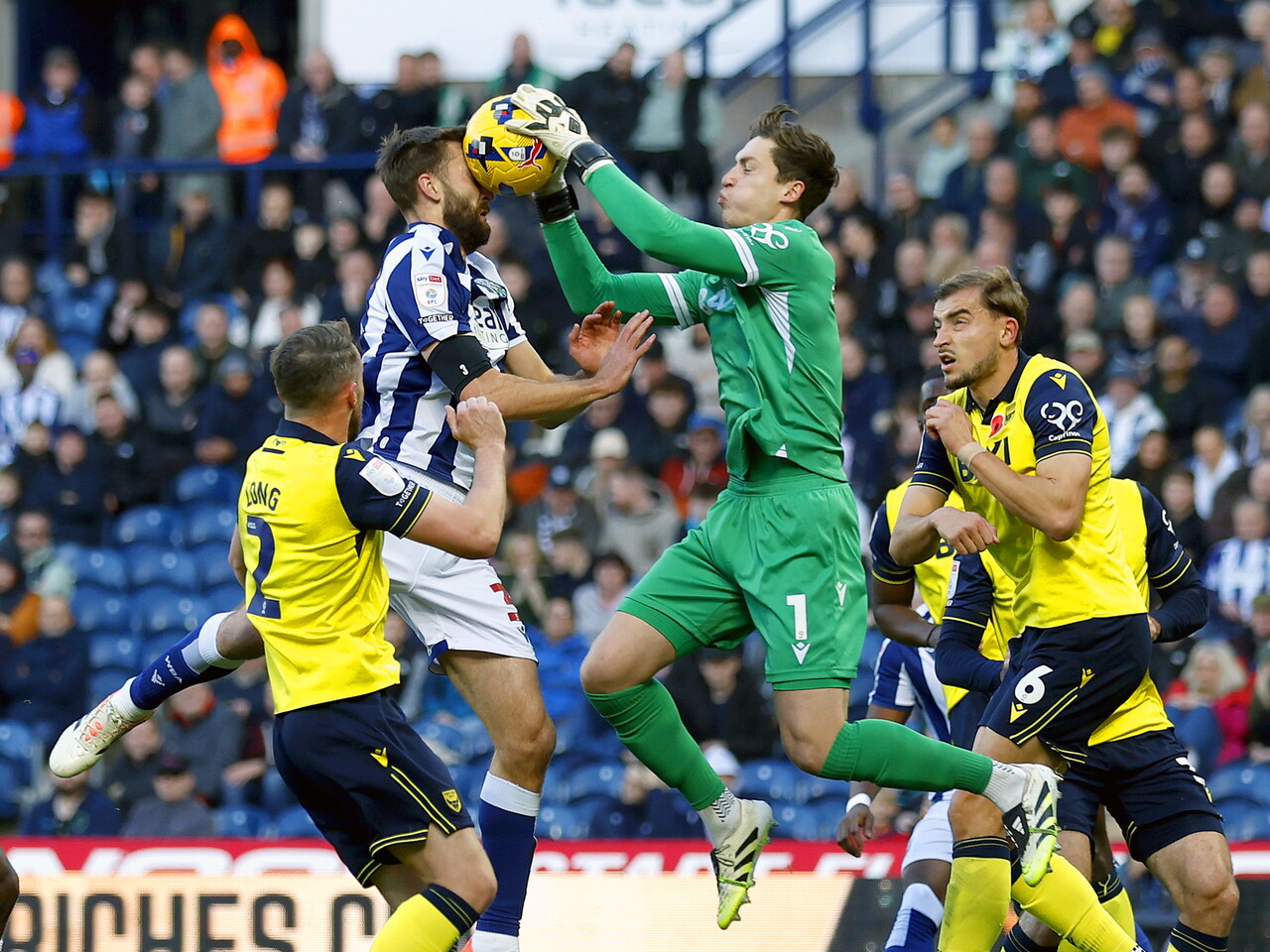 Nat Phillips and the Oxford United goalkeeper battling for the ball in mid-air at The Hawthorns