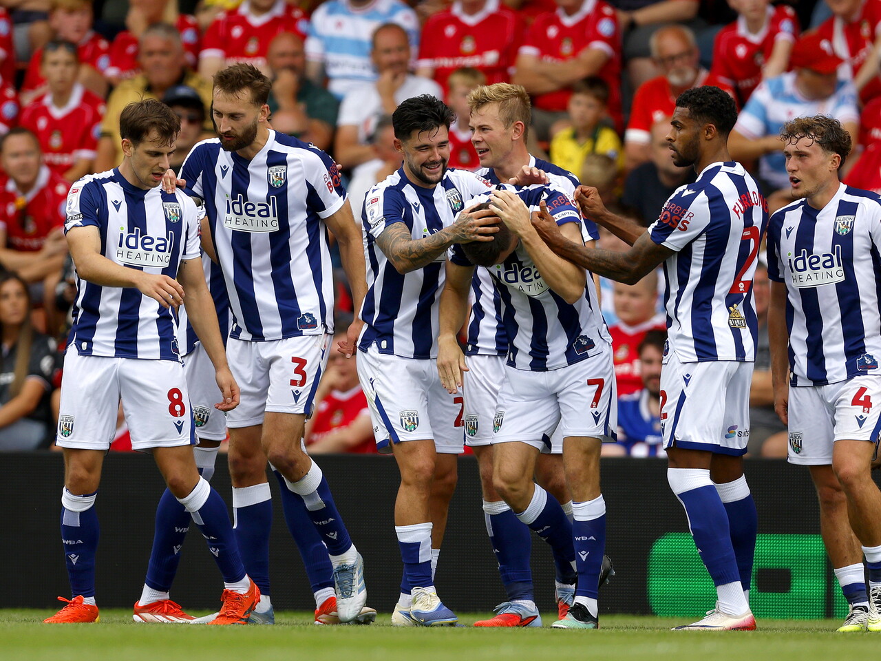 Several WBA players celebrate with Jed Wallace after his goal at Wrexham in the home kit 