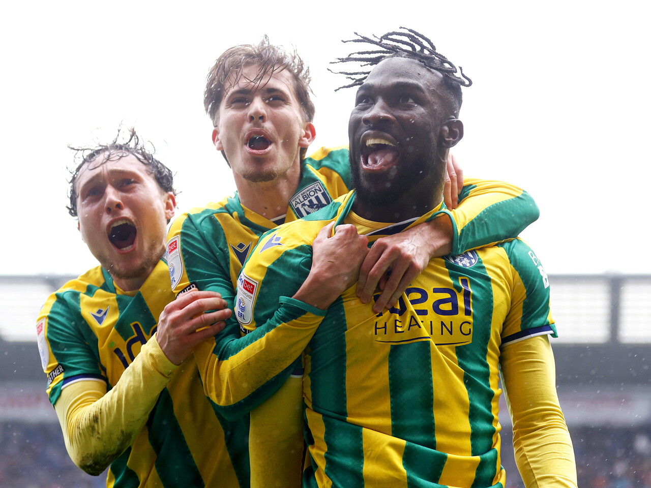 Daryl Dike celebrates scoring at Preston North End in the green and yellow away kit with Callum Styles and Isaac Price