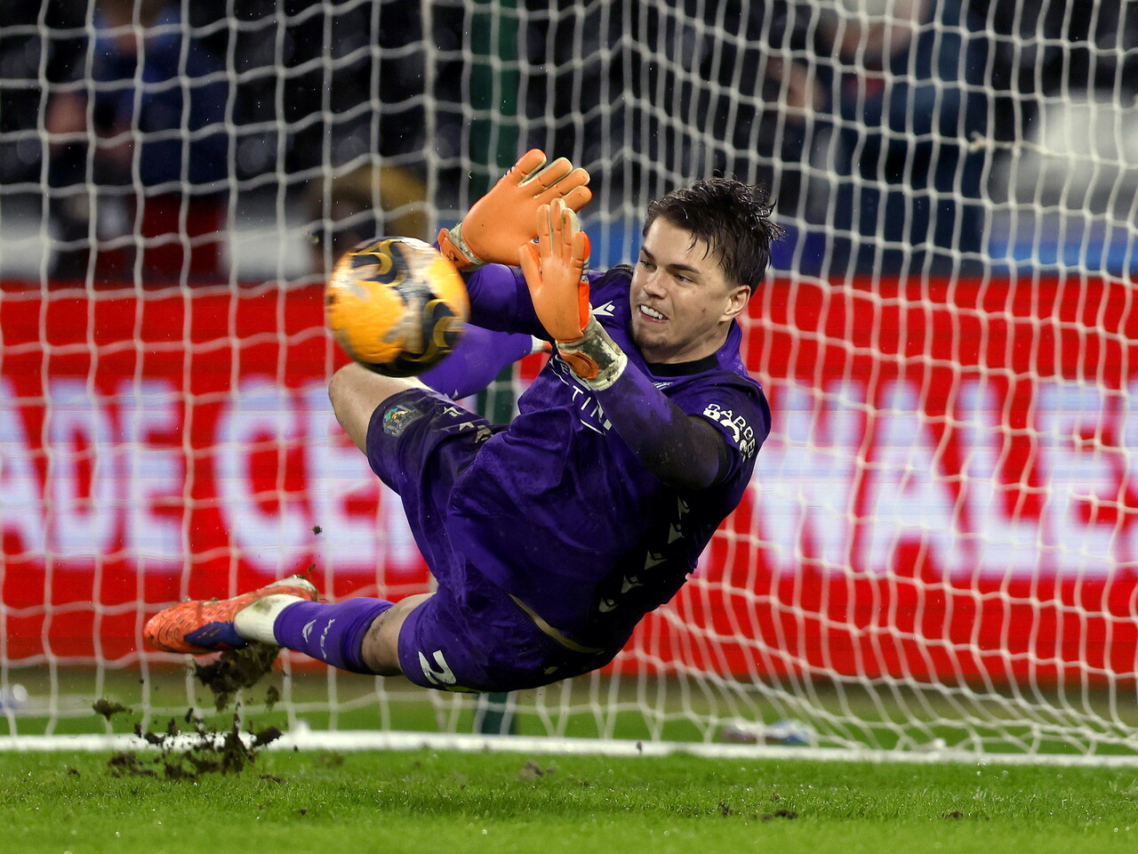 Josh Griffiths diving to make a save from a penalty during the FA Cup game at Swansea City 