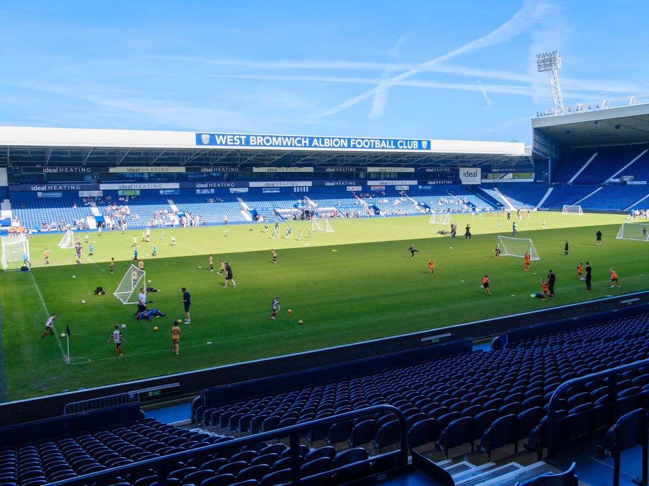 View from the East Stand of players warming up on the pitch and West Stand.