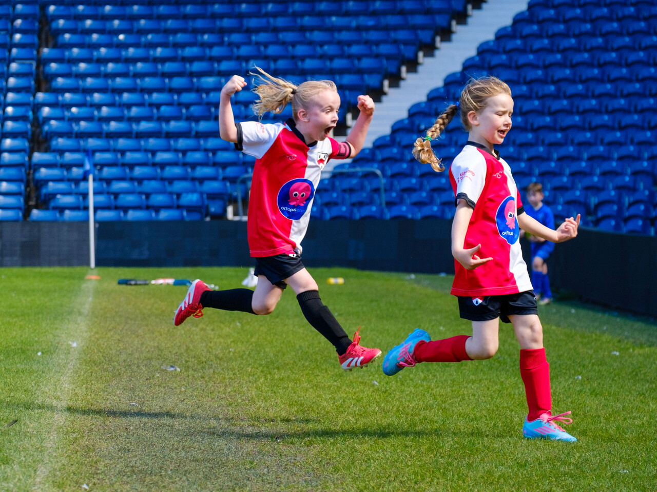 Two Old Wulfrunians Girls running off the pitch, celebrating a goal.