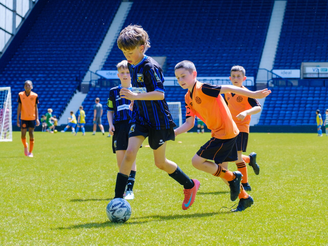 Player in possession of the ball, with a defender chasing.