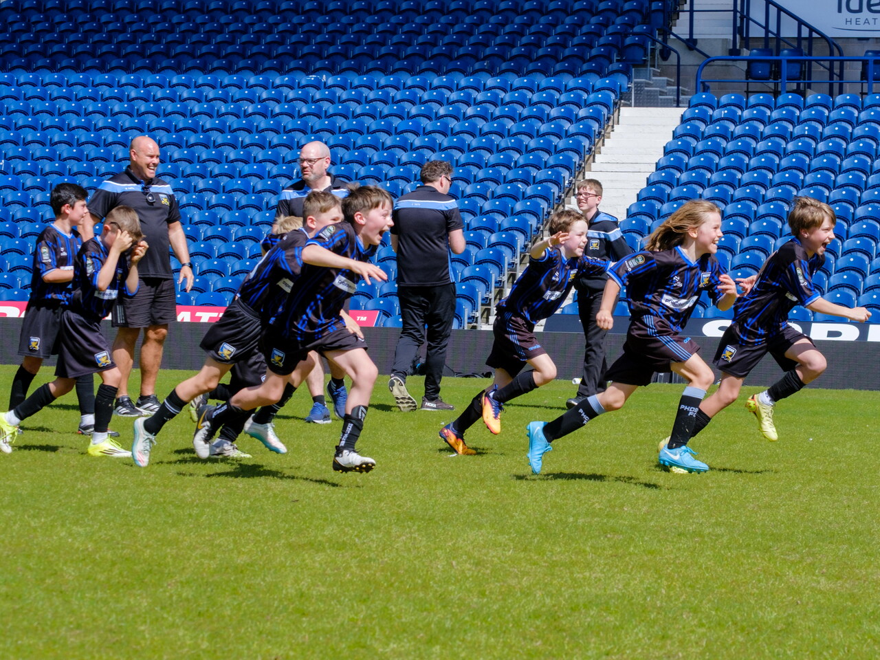 Phoenix FC running in celebration after winning the penalty shootout.