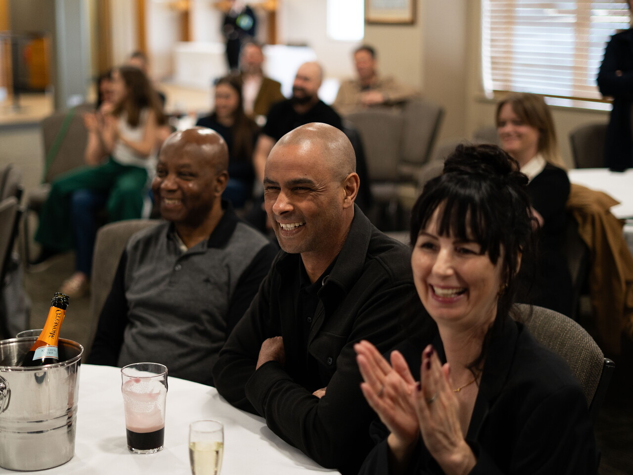 Close-up of parents smiling and applauding.