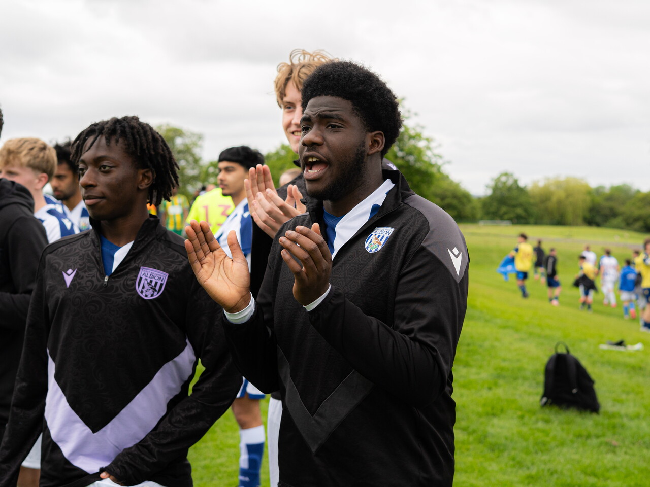 Players on the sideline cheering on teams.