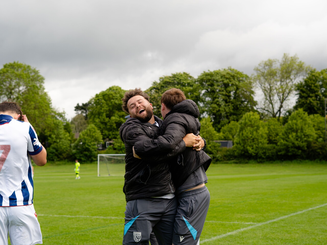 Coaches hugging in celebration.