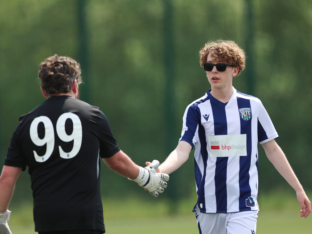 WBA player shaking hands with the opposing goalkeeper.