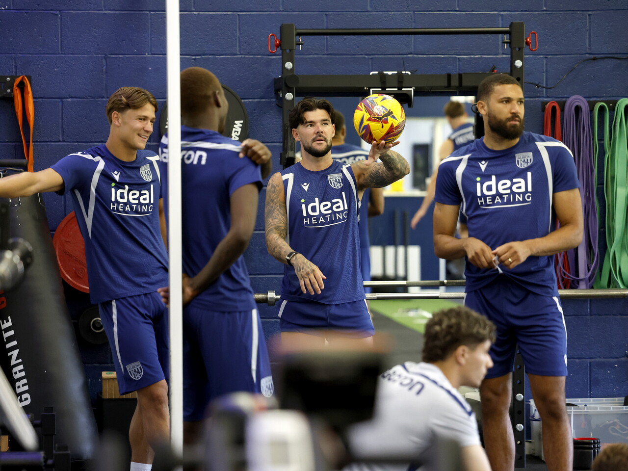 Cole Deeming, Alex Mowatt, George Campbell and Eseosa Sule chat in the gym.