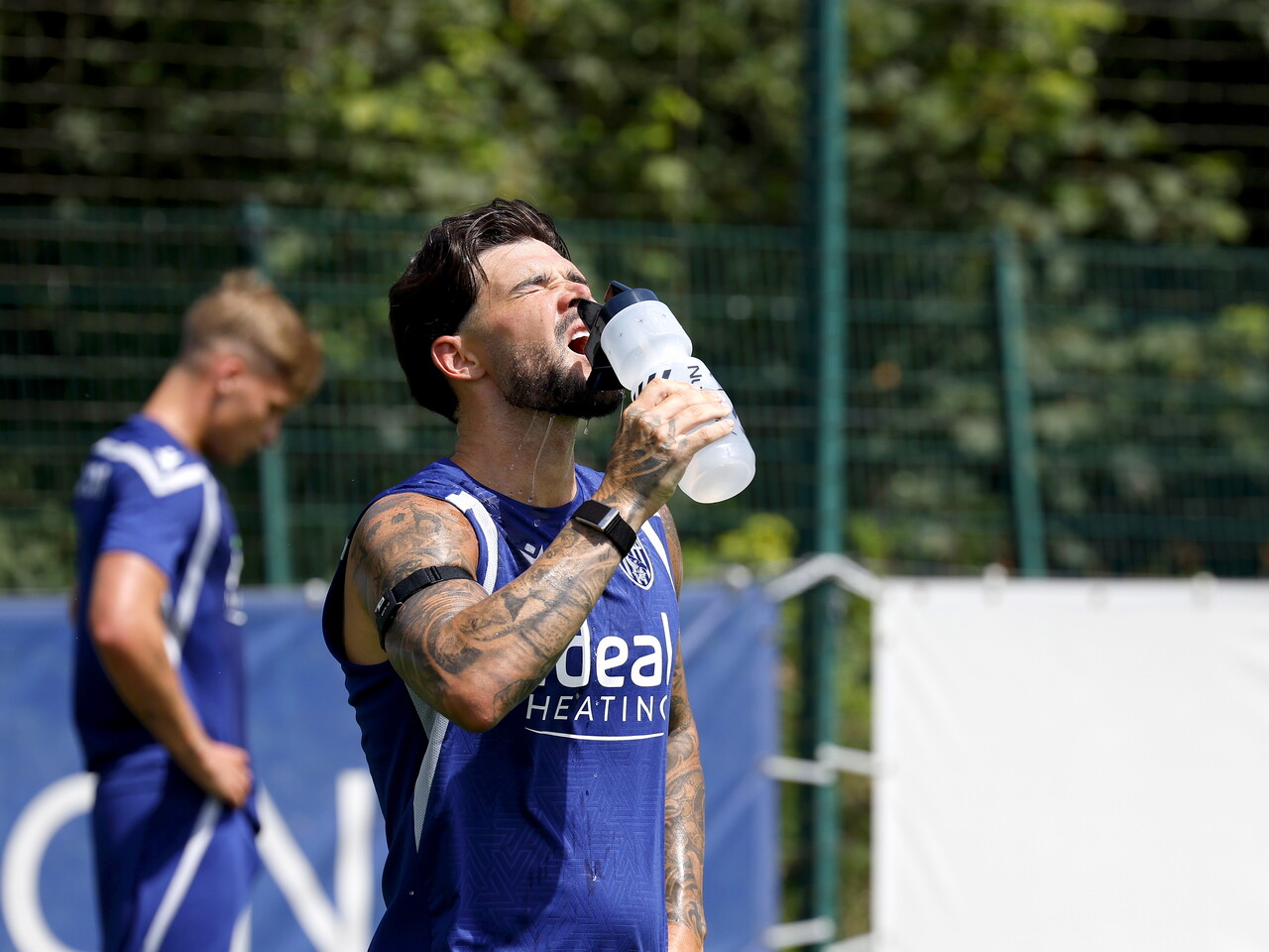 Alex Mowatt drinks water on the training pitch.
