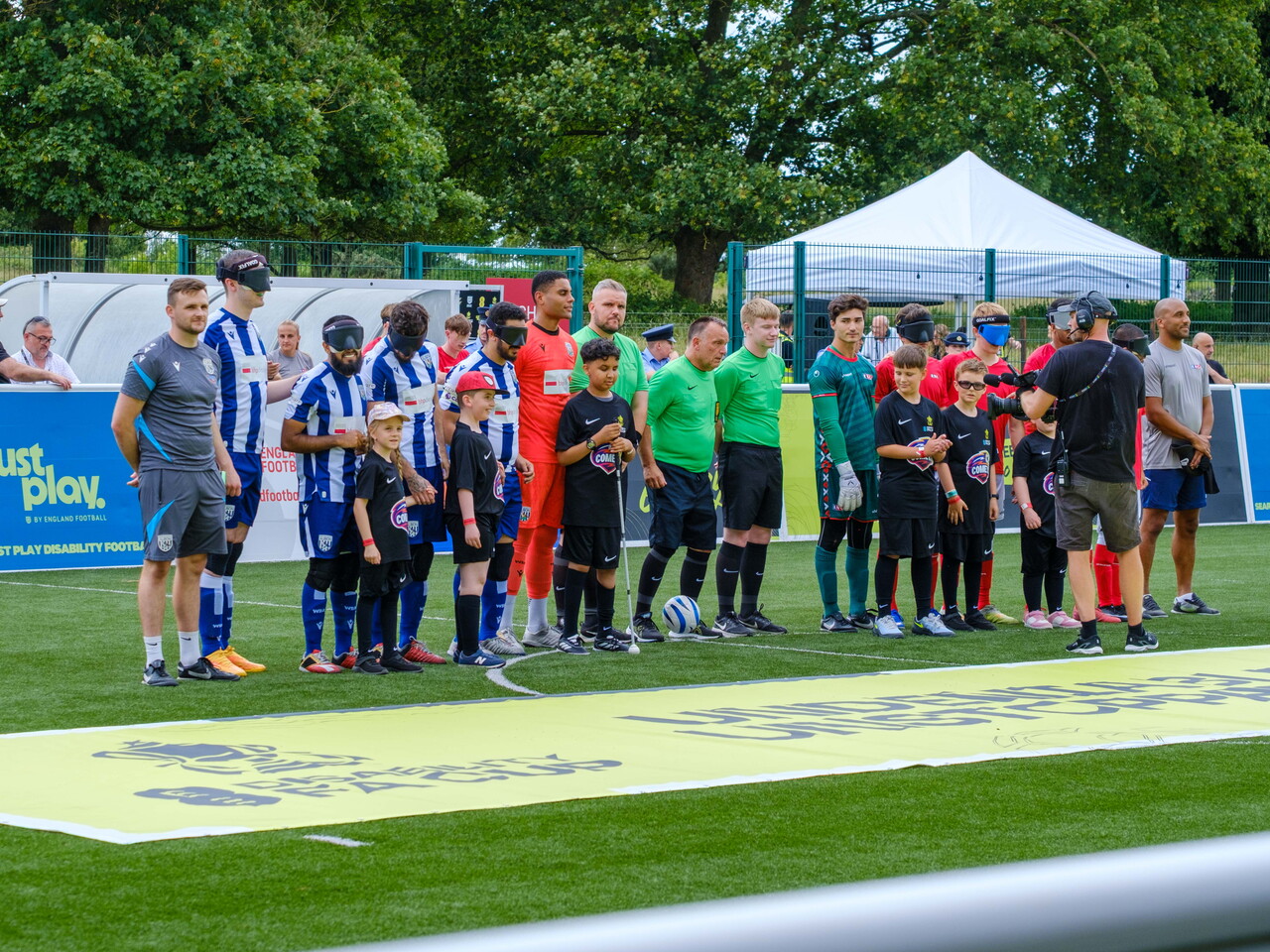 Both teams lined-up with referees and mascots.