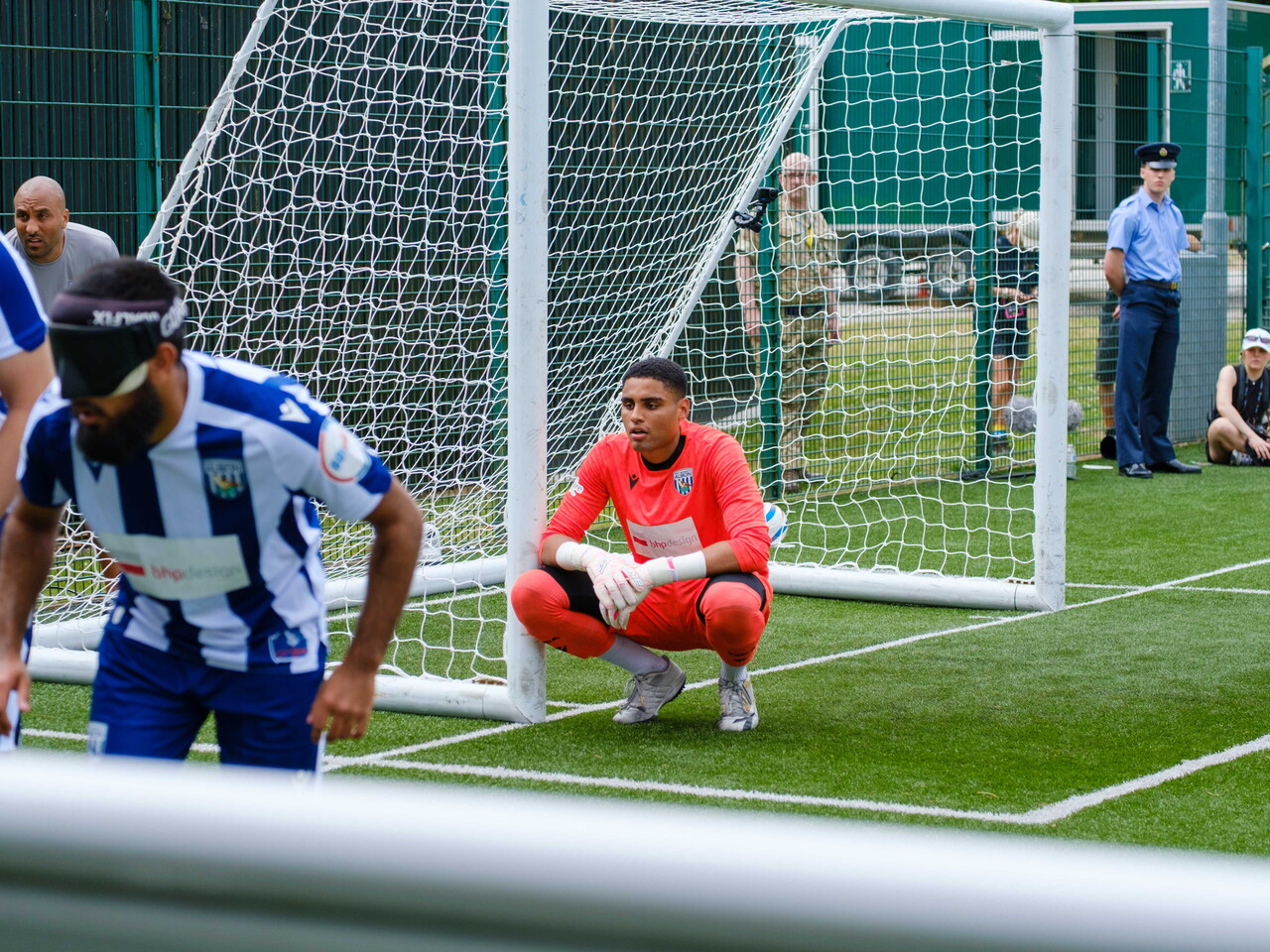 Goalkeeper Owen Locke, kneeling, as Eesa and others set up in a wall to defend a RNC corner.