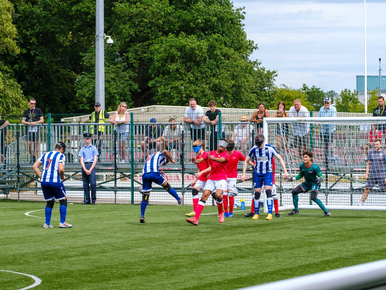 Eesa striking the ball with a sea of players in front of goal.