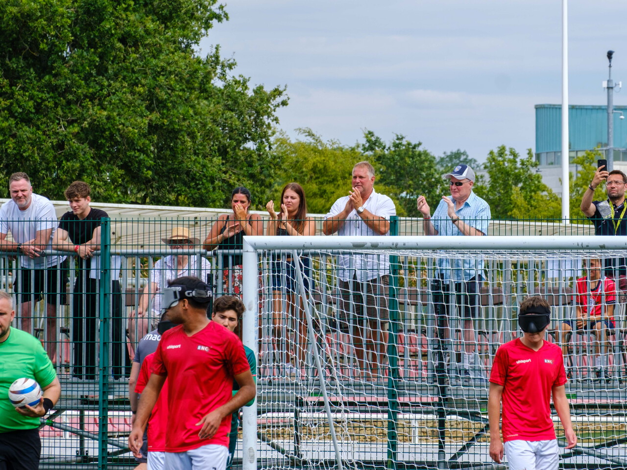 Spectators applauding a WBA goal, with the referee taking the ball to the centre circle.