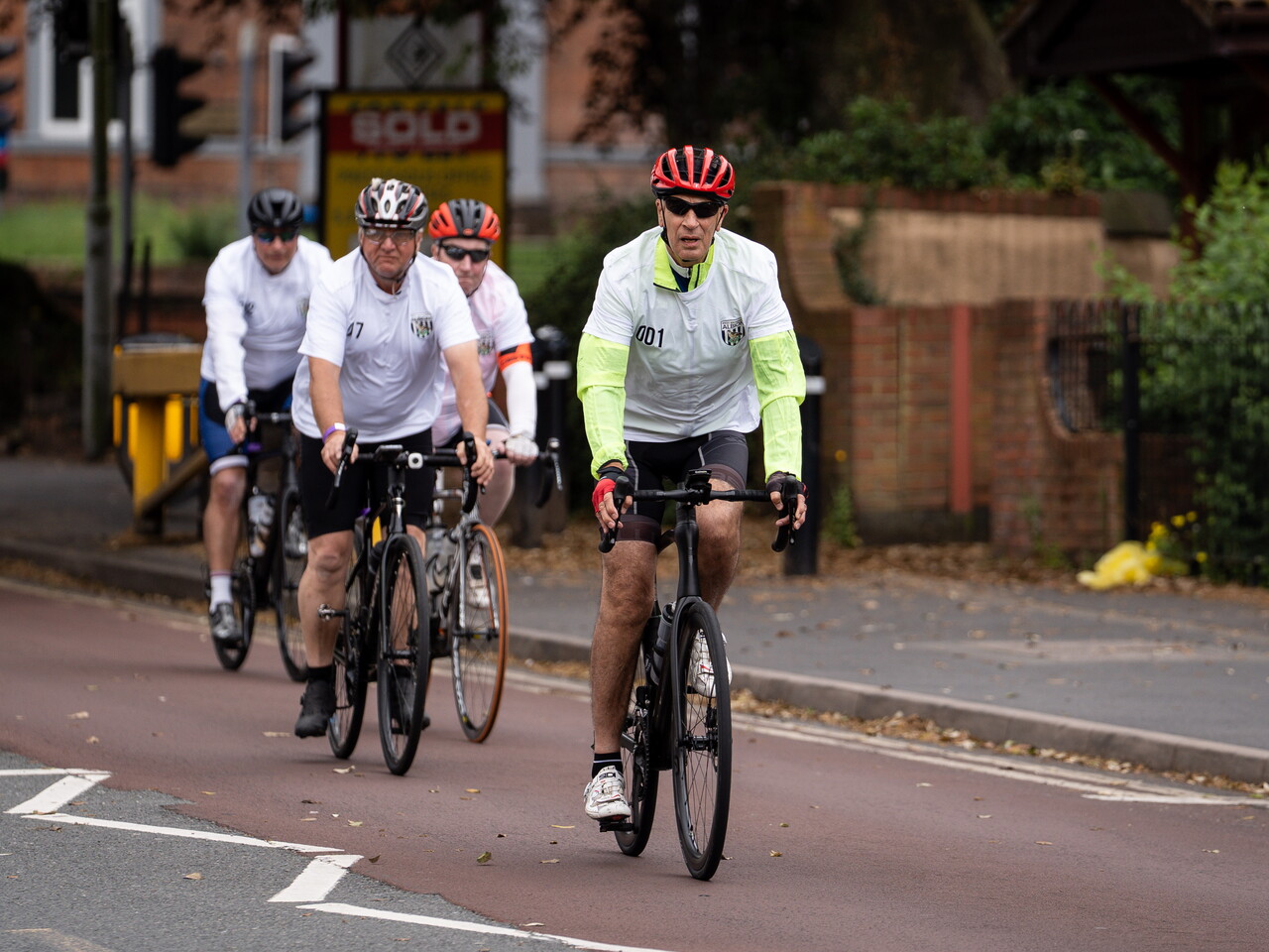 Albion cyclists riding in formation along a road during a cycling challenge.