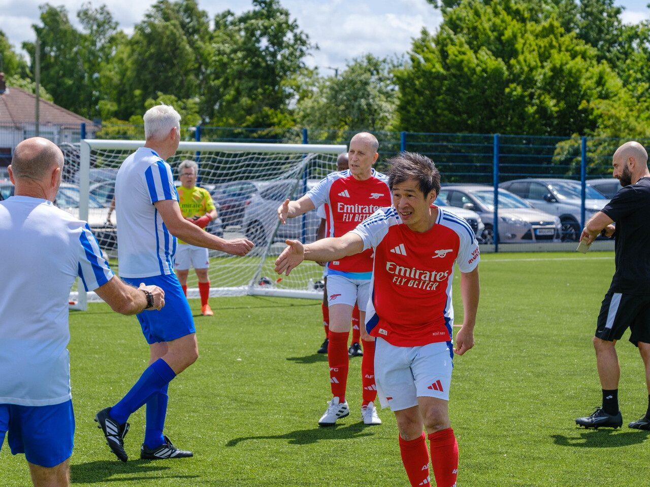 Arsenal players reaching out for a hand shakes with Movers and Shakers players 
