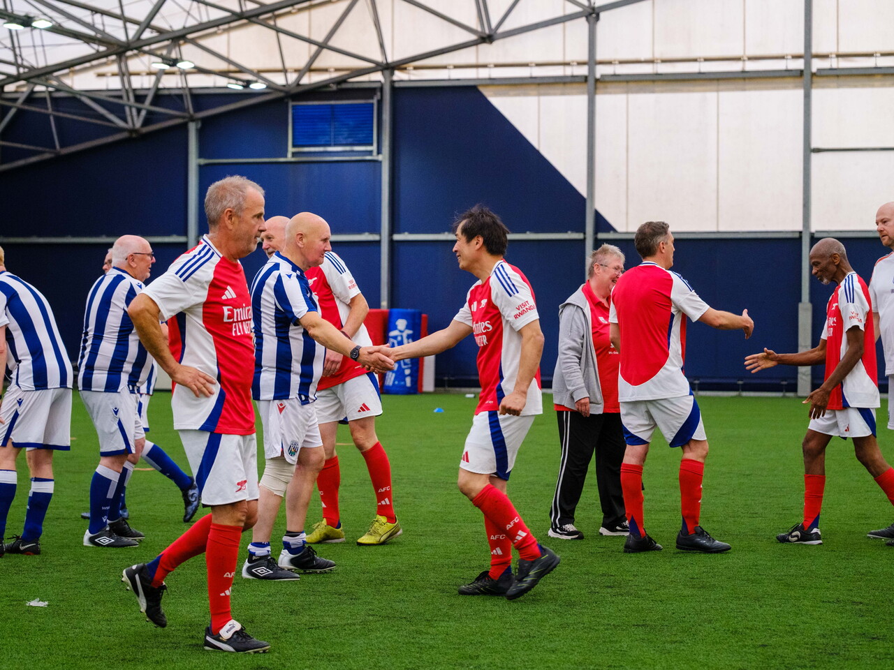 Arsenal and Cancer Kickers shaking hands after the game.