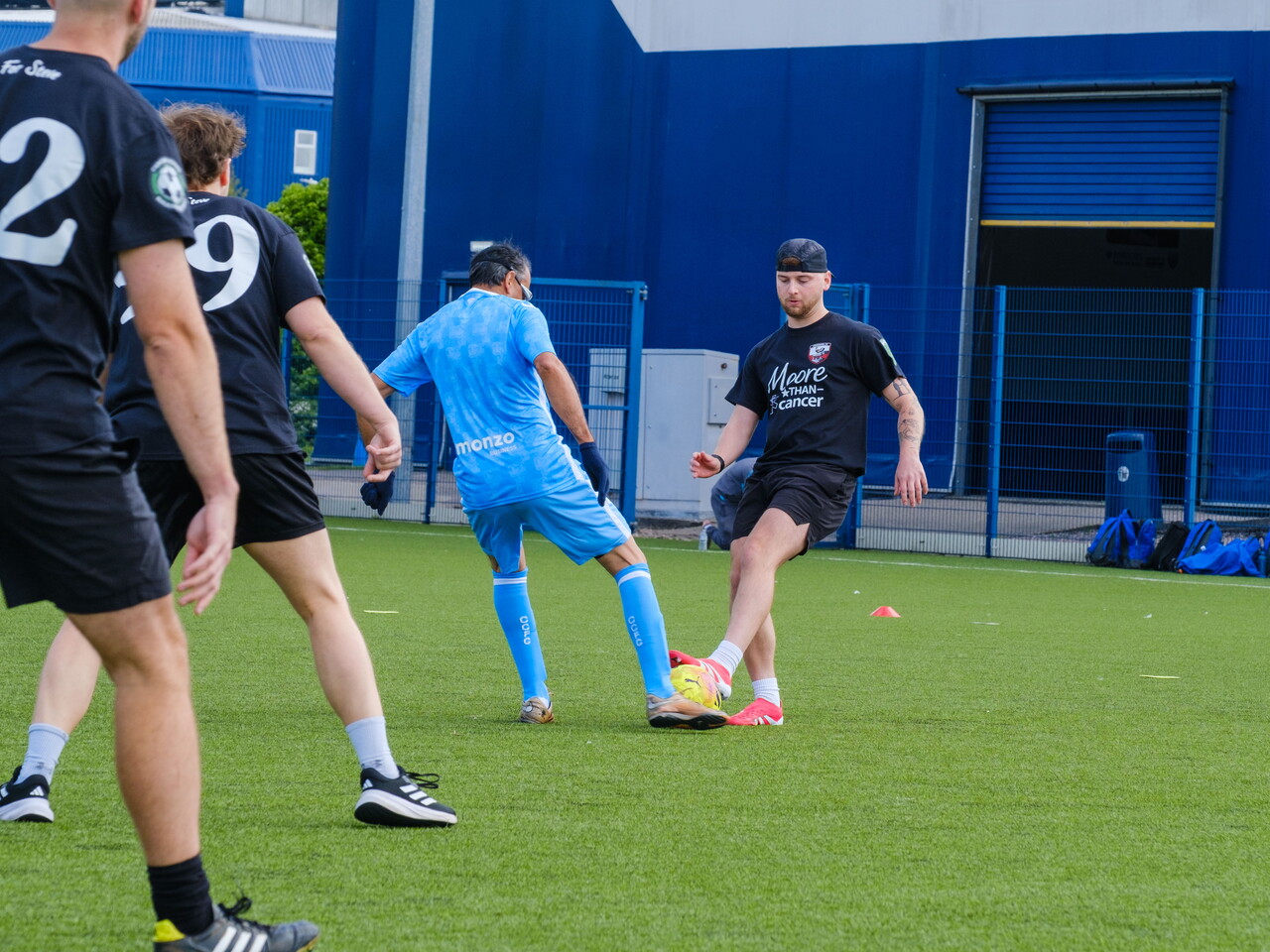 Sky Blue in the Community and Moore than Cancer player challenging for the same ball.