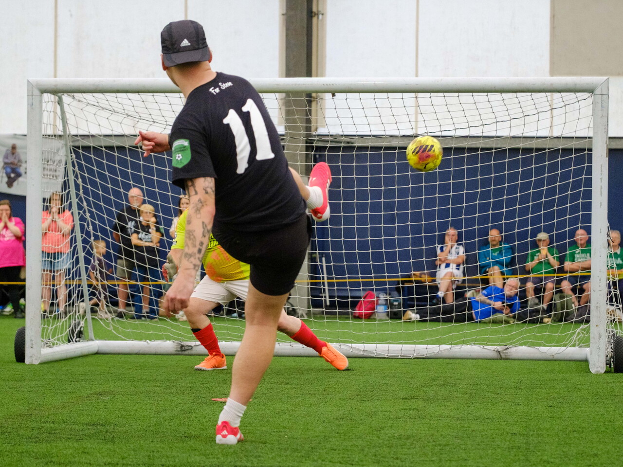 Moore than Cancer player striking his penalty with Arsenal goalkeeper diving the opposite way.